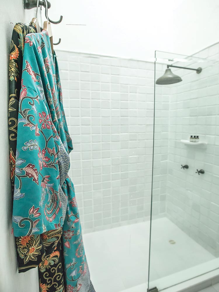 Two silk dressing robes hanging in the shower